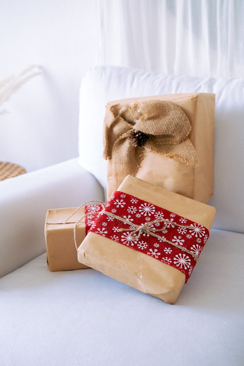 Cadeaux de Noël emballés posés sur un canapé, idée de cadeau de Noël pour un couple