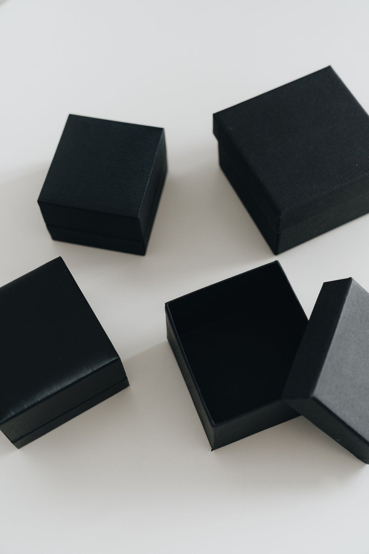 Coffret cadeau de parfum d'intérieur : écrins noirs minimalistes posés sur une table claire