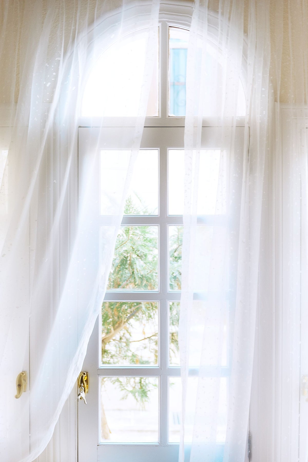 Voilage traversé par la lumière dans un intérieur calme, illustrant comment fonctionne un diffuseur à nébulisation qui parfume l'air sans eau ni chaleur