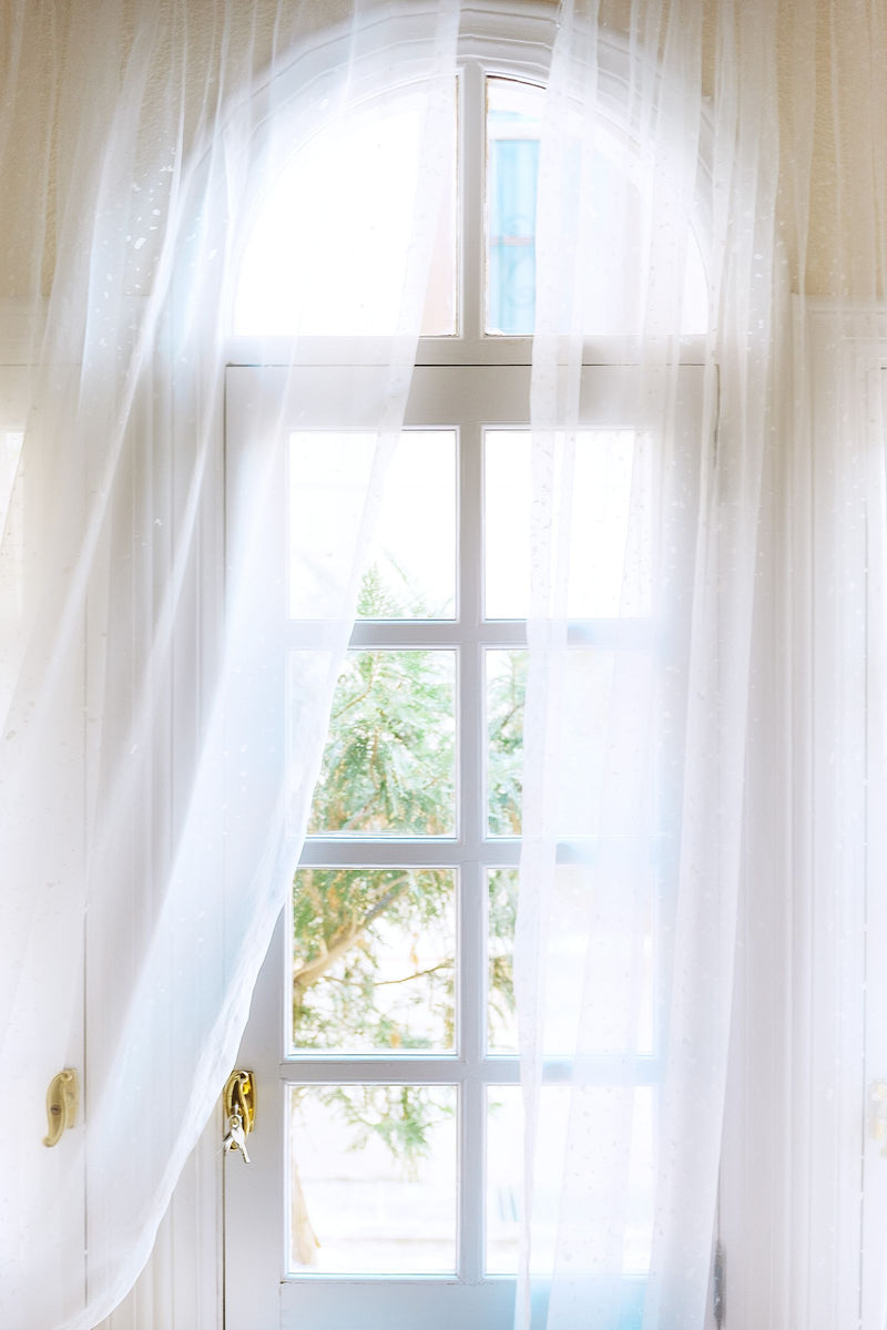 Voilage traversé par la lumière dans un intérieur calme, illustrant comment fonctionne un diffuseur à nébulisation qui parfume l'air sans eau ni chaleur