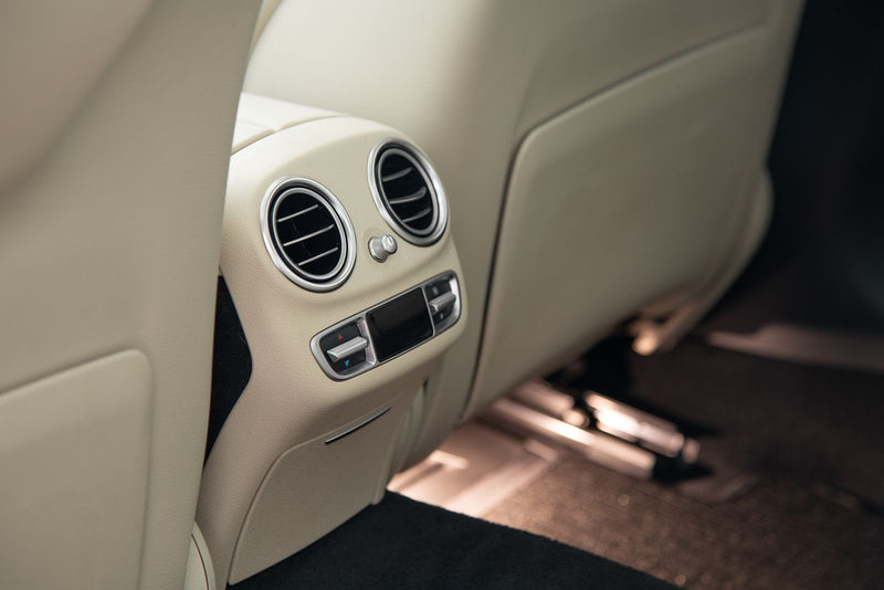 Console arrière en cuir beige et aérateurs chromés d’une berline : quelle senteur pour une voiture haut de gamme