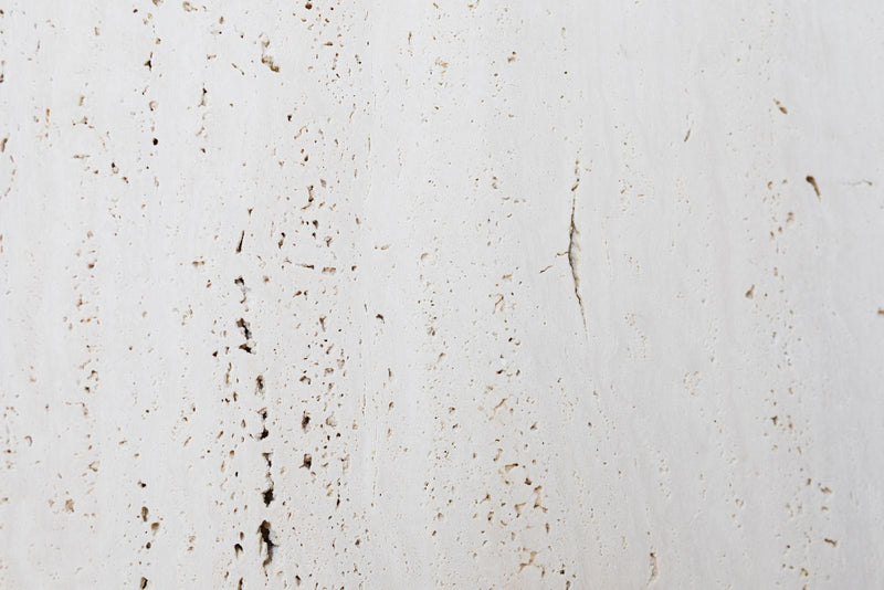 Mur de travertin clair, matière minérale choisie pour illustrer comment régler un diffuseur de parfum sans application